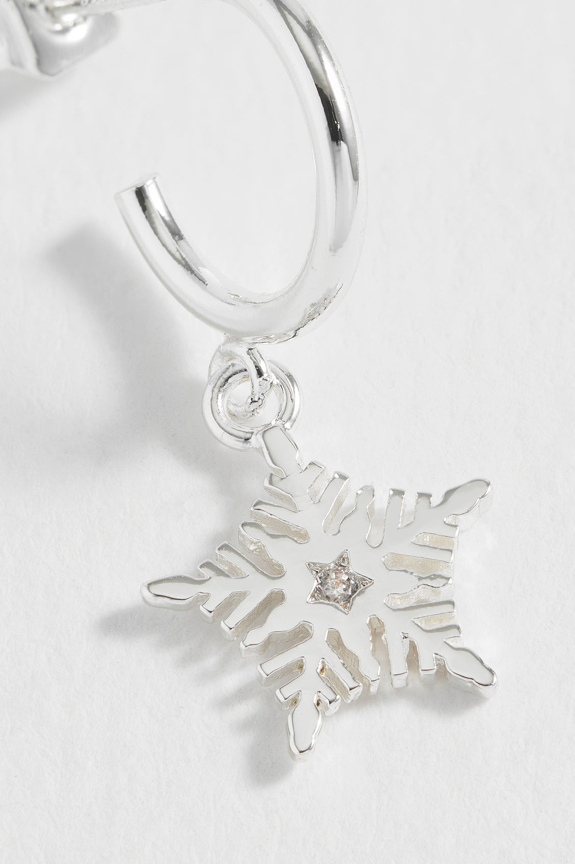 Silver snowflake charm on a white background