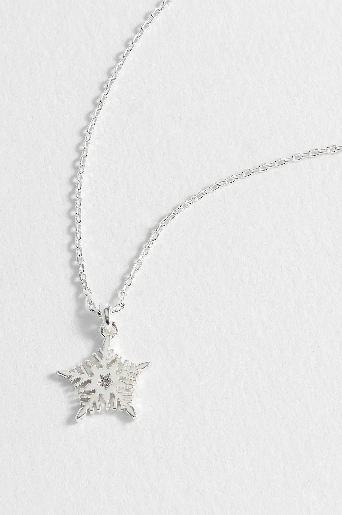 Silver snowflake pendant necklace on a white background