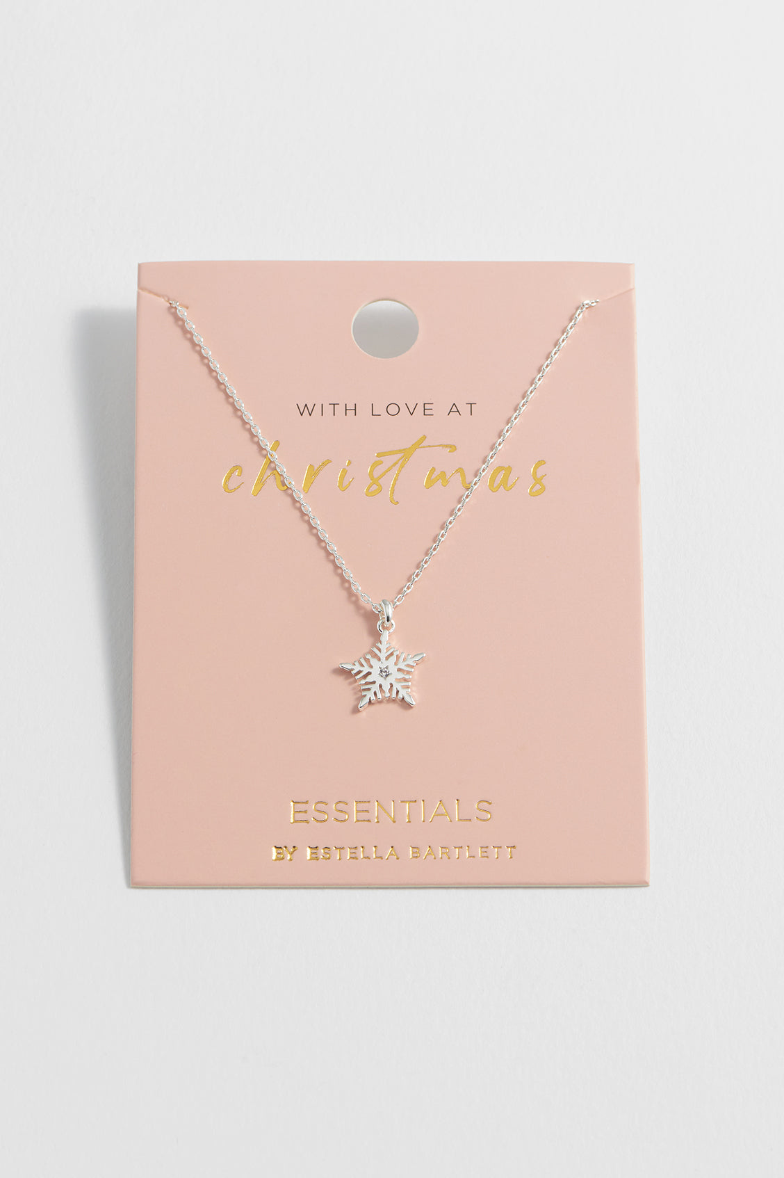 Star-shaped necklace on a pink card with 'Essentials' branding